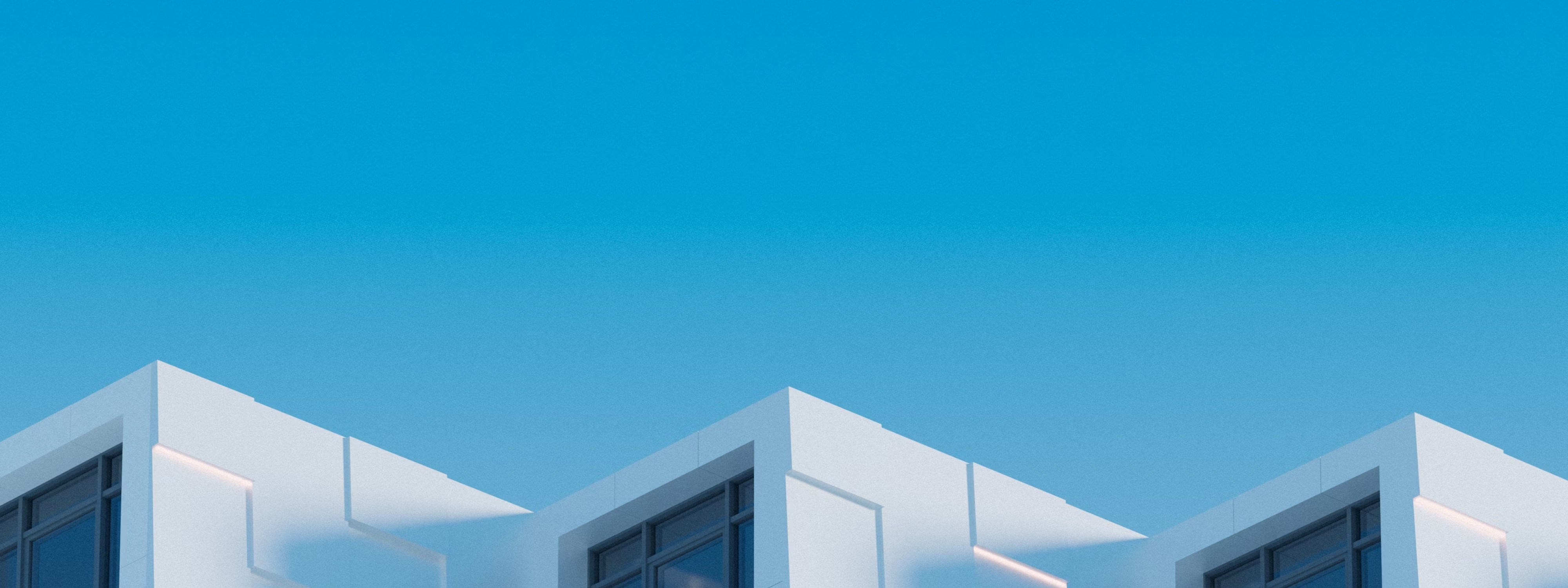White modern buildings against clear blue sky with geometric windows