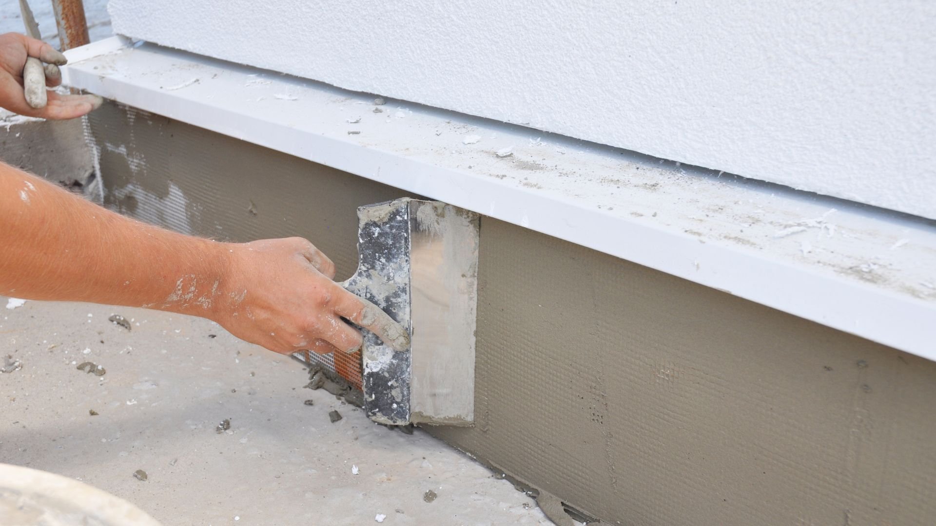 Construction worker applying plaster or cement with a trowel